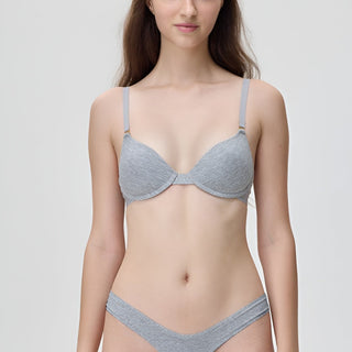 Woman wearing a gray bra and underwear set on a plain background
