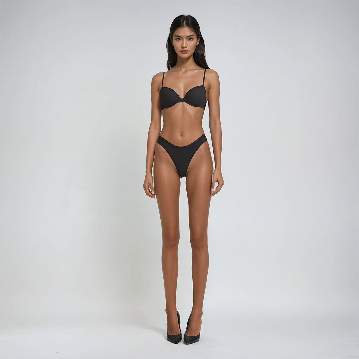 Model wearing a black bikini on a white background