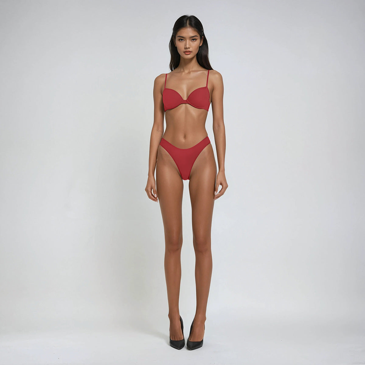 Model wearing a red bikini set on a white background