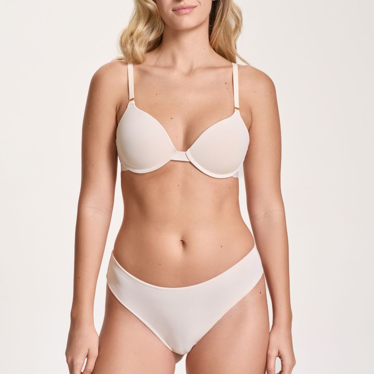 Woman wearing a white bikini on a plain background