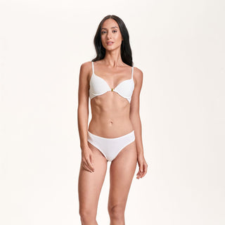Woman wearing a white bikini on a plain background