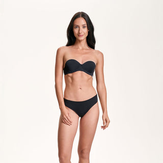 Woman wearing a black strapless bikini on a white background