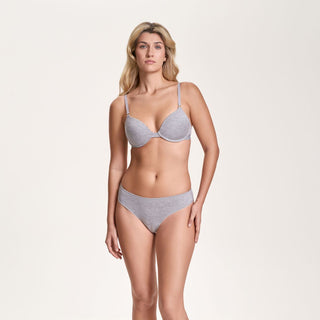Woman wearing a gray bra and panties set on a beige background