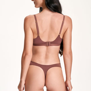 Woman wearing a brown bra and panties set on a white background