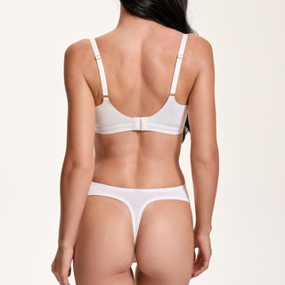 Person wearing a white bra and panties set on a plain background