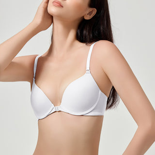 Woman wearing a white bra against a plain background