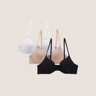 A set of three Anytime Seamless T-Shirt Bras in different colors (white, beige, and black) displayed against a neutral background.