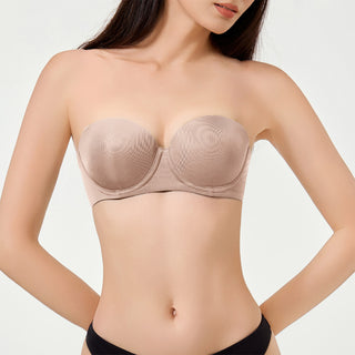 Woman wearing a beige strapless bra against a plain background