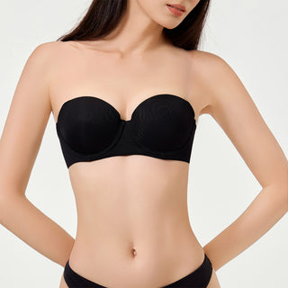 Black strapless bra worn by a model on a white background