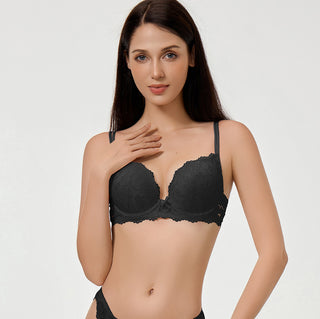 Woman wearing a black bralette on a plain background
