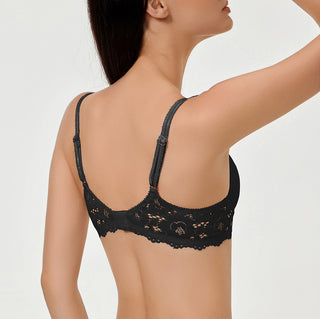 Black lace bra worn by a model on a plain background