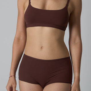 Person wearing a brown bikini set against a gray background