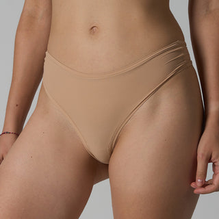 Beige underwear worn by a person on a plain background