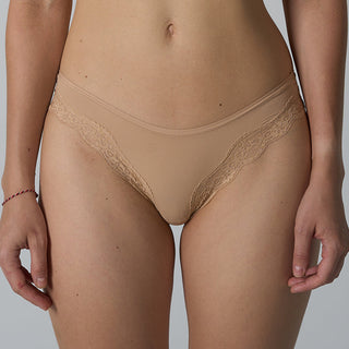 Beige lace-trimmed underwear worn by a person on a plain background