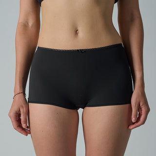 Person wearing black underwear on a gray background