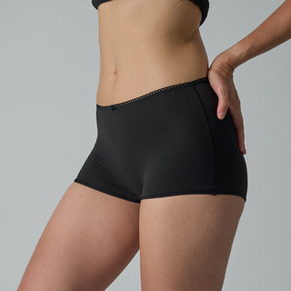 Person wearing black underwear on a gray background