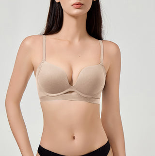 Woman wearing a beige bra on a plain background
