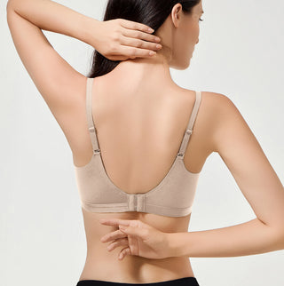 Woman wearing a beige bra on a plain background