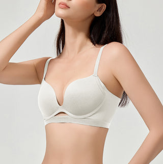 Woman wearing a beige bra against a plain background