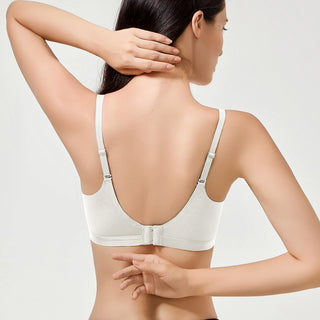 Woman wearing a white bra on a light gray background