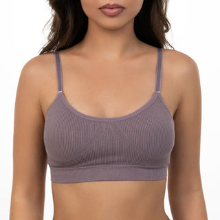 Woman wearing a ribbed purple sports bra on a white background