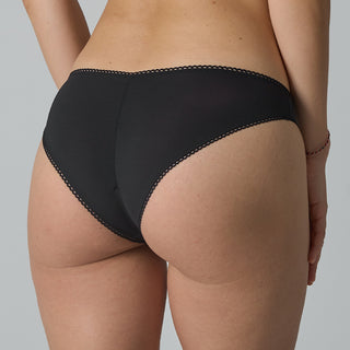 Black bikini bottom worn by a person on a gray background
