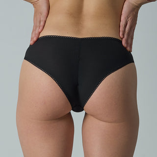 Person wearing black underwear on a plain background