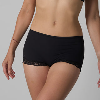 Black lace-trimmed underwear worn by a person on a gray background