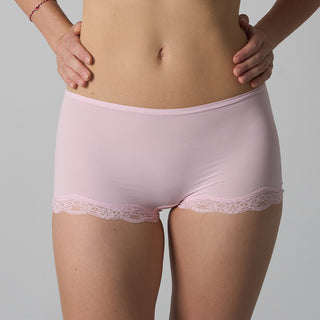 Light pink underwear with lace trim worn by a person on a gray background