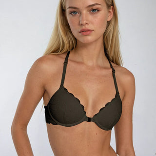 Woman wearing a dark bra against a white background